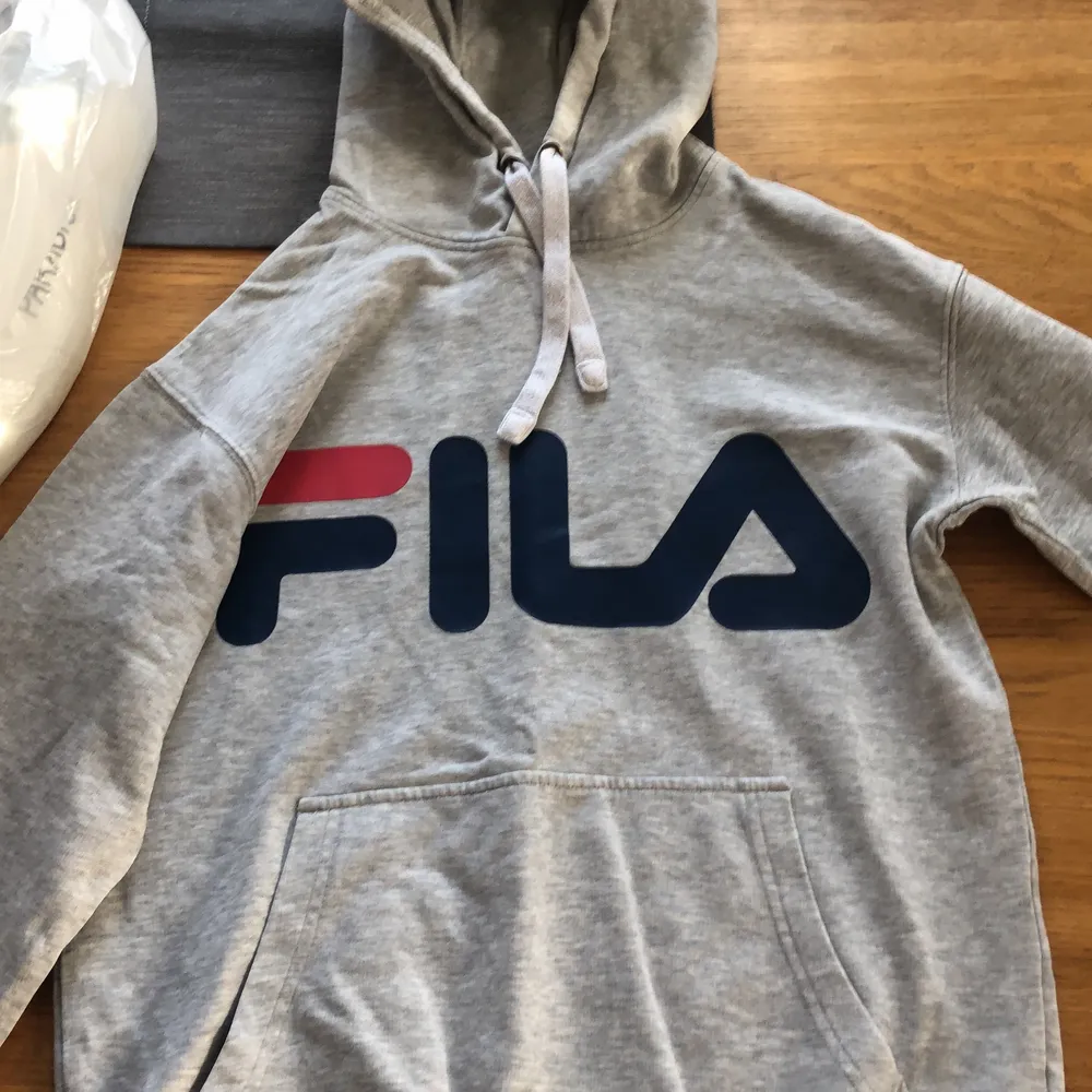 En grå Fila hoodie i strlk XS, lite trasig på höger ärmen eller vad det heter (se bild). Hoodies.