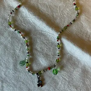 Halsband med gröna, vita och röda pärlor och en körsbärs-berlock🍒 pris: 100kr