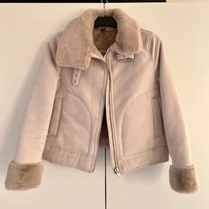 H&M fuskpäls jacka i mocka  - Jacka i mocka med fuskpäls, väldigt mjuk och i en biege aktig färg. Funkar bra på höst / vintern. Väldigt skön och snygg! Från H&M använd fåtal gånger