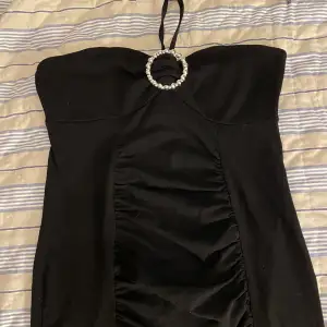 En svart halterneck klänning med silver detalj super fin till nyår 