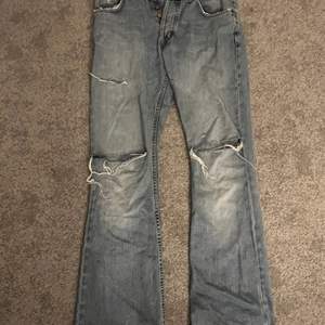 säljer nu dessa unika jeans från märket lee, de sitter lågmidjat med hål på knäna och lite slitningar. byxorna är väldigt slitna som man ser på bild nr 3 för de är väldigt långa. Det syns dock inte så mkt eftersom det är på baksidan.