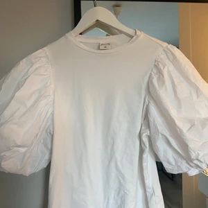 Vit T-shirt  - Vit T-shirt med volang ärmar som gör en enkel outfit så mkt coolare❣️❣️nästan helt oanvänd!!! Johanna Ortigs kollektion:)