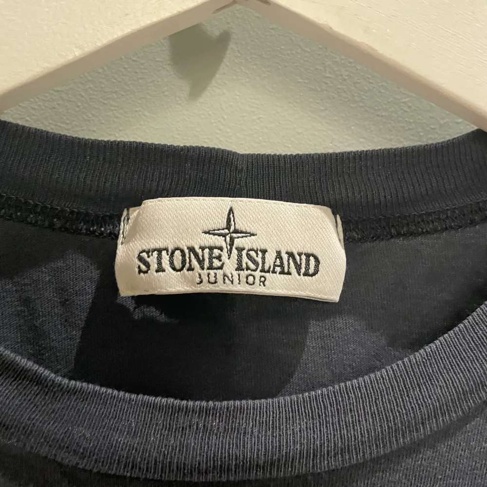 Fin mörkblå stone island T-shirt i junior storlek. Skulle säga att motsvarigheten är en xxs-xs i unisex modell. Använd men mycket fint skick och inga defekter!. T-shirts.