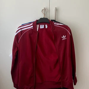 adidas kofta  - As snygg kofta från adidas i vinröd färg. Säljer pga rensar ut garderoben. Knappast använd Strlk: 13-14 år men sitter som en xs-m passar på mig som har de  