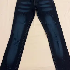 Mörk blåa jeans med små ljusa delar på jeansen. De är köpta i London 2006. Storlek på jeansen är 26.