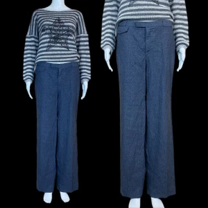 Gråa Kostymbyxor - Kostymbyxa i fint skick, vintage(?) Vet ej material men känns mjukt. Ficka finns på framsidan. ⚠️Grå färg! Högmidjade men sitter lite lågmidjad på dockan! ⚠️ Mått: Midjebredd 40cm, grendjup 26cm, höftbredd 50cm & innerbenslängd 78cm.