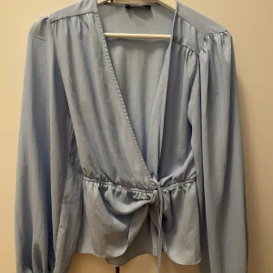 Ljusblå blus - Hej här är en fin ljusblå blus från trendyol, den är i storlek xs/34 men lite större i storleken då jag har S/36 i storlek. Den är begagnad men i jätte bra skick.  Hör av dig för frågor 😊 Mvh Hanna