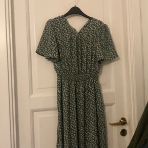 Grön blommig sommarklänning  - Fin lång blommig klänning med resår vid midjan. 