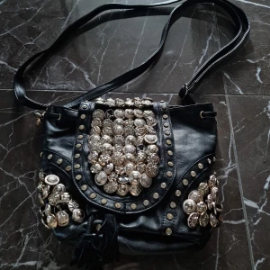 Helt ny väska, rikligt med detaljer - Helt ny väska som verkligen sticker ut. Rikligt dekorerad, 30 cm lång och 23 cm bred. Köparen betalar frakten.