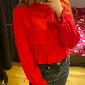 Röd söt blus, skön & lätt att ha på sig - Säljer denna röda blusen. Blusen är gjort av ett väldigt skönt tunt material. Den är perfekt för sommaren/ våren då den inte är för tjock. Den har ett elastiskt band vid magen och handleden som gör den ”puffig”