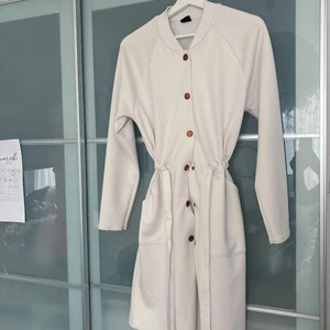 Vit kappa - Vit kappa från ginatricot använd ett fåtal gånger men är i bra skick, knapparna ska vara bronsfärgade som syns på bild! 