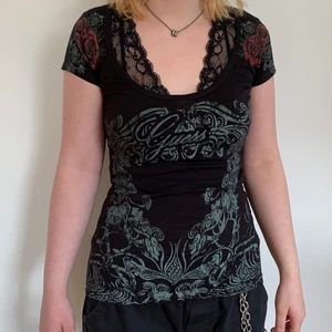 GuessJeans Linne, S/P, Svart med blommor - Vintage svart linne från Guess köpt i New York, med logga på bröstet, blommor på axlarna och övrigt tryck på plagget. Storleken är small/petite.