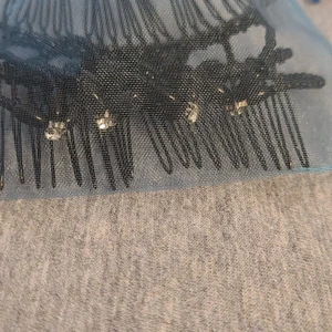 Shein - Det är en svart hårklämma med silvriga kristaller som skiner.