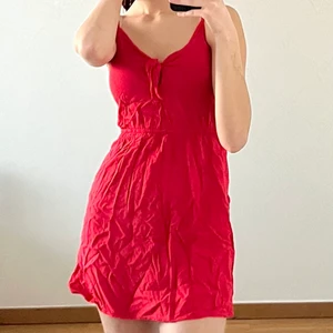Röd sommarklänning  - Kort, röd sommarklänning med justerbara axelband och detalj på urringningen! Har använts fåtal gånger tidigare. Ingen retur. Alla plagg som säljs tvättas noga innan leverans! Det är bara att skriva om du har några frågor! <3. 