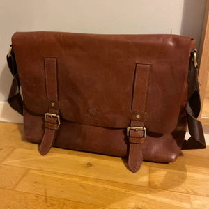 Brun skinnväska - Hej! Säljer min bruna skinnväska med flera olika fack inuti!  Väskan är äkta skinn, väskan är även i bra skick och bara används fåtal gånger. Väskan har inga märkbara slitningar och är precis som en nyköpt väska!  Mer bilder om hur den ser ut inuti kan skickas om man är intresserad. 