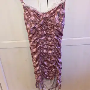 Blommig lila/rosa klänning i tight modell 