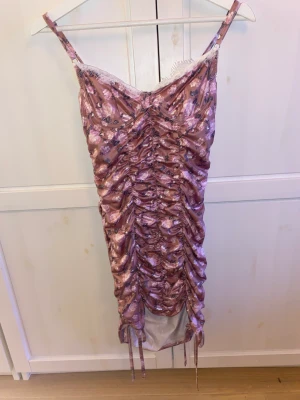 Blommig klänning - Blommig lila/rosa klänning i tight modell 