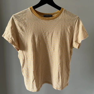 Randig T-shirt Brandy Melville  - Randig T-shirt från Brandy Melville. Storleken är onesize, men skulle säga att storleken är som en M/S. I fint begagnat skick. Den gula färgen på tröjan är mer gul i verkligheten än på bilderna.
