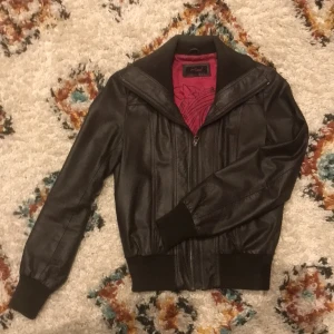 Skinnjacka - Brun skinnjacka från redlabel, supersnygg med rosa foder och muddar i ärmslut samt midja.