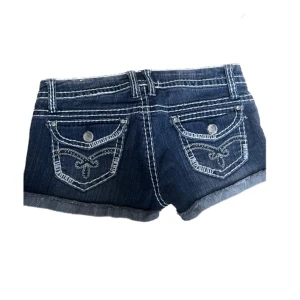Y2k shorts - Assnygga lågmidjade jeansshorts med coola detaljer. Midjemåttet är 76cm men dom är lite stretchiga typ. Passar mig med xs/s. 