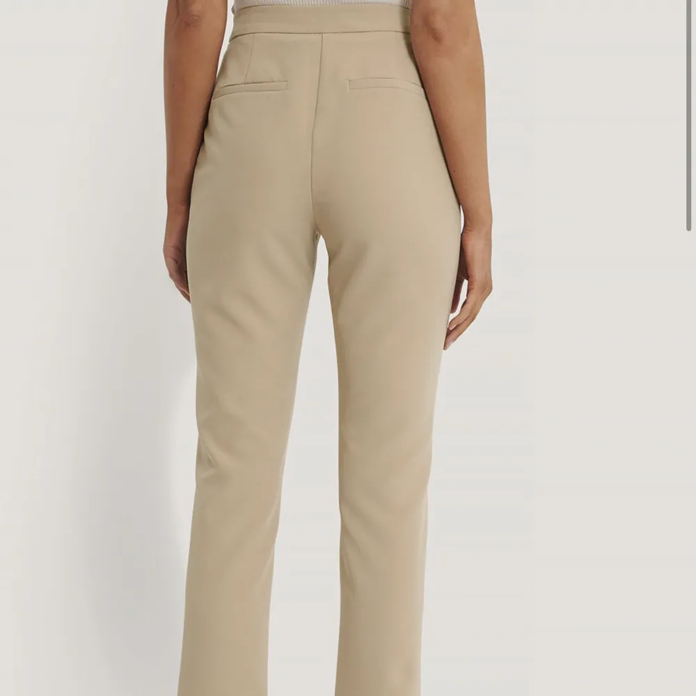 Beigea kostymbyxor från NA-KD. Använd ca 2 gånger. Mycket gott skick. Köpare står för frakt. Aningen stor i storleken, Stl 32 men känns som en 34.. Jeans & Byxor.