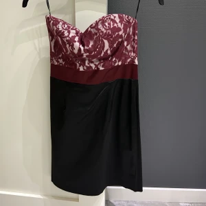 Klänning - En kort bandeau fest klänning från Elise Ryan. Aldrig använd. På etikett står storlek 10/M men det passar lätt S eftersom Elise Ryan har små storlekar. Vinröd och svart i färg.