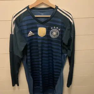 Säljer en fin Tyskland-tröja, VM-utgåvan från 2018. Tröjan är helt äkta och i mint condition, knappt använd. Kan skickas i Sverige mot betalning. 