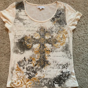 t-shirt - Säljer denna ascoola t-shirten med ett jättesnyggt mönster och rhinestones på framsidan, dock har några stenar trillat av men det märks knappt🤍💛den är stl S men sitter lite oversized på mig som är 167. Högst bud vinner men kan sälja direkt för 200+frakt:)