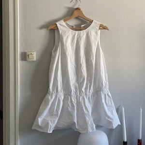 Puffig Zara klänning - Vit Zara klänning med volang längs ner! Storlek small, perfekt för student och sommaren! Insydda shorts under som ej syns för att ej flasha och djup urringning baktill i ryggen, 100% bomull.