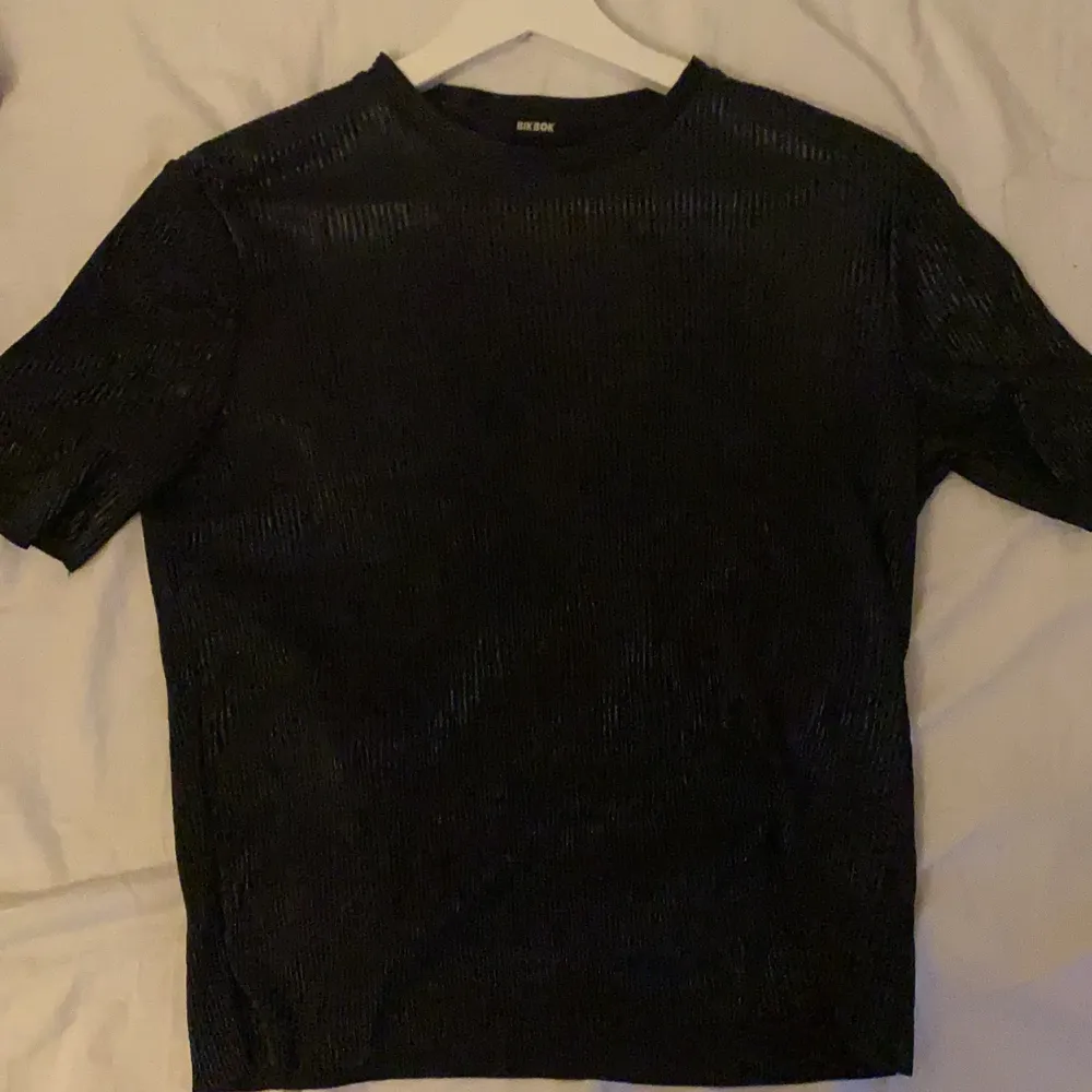 En svart skimrig tröja i ett skönt tunt material . T-shirts.