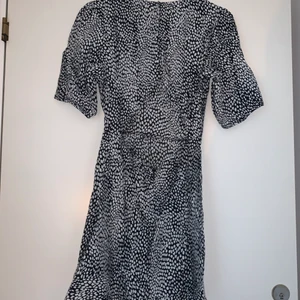 Klänning med öppen rygg från Nakd. - Säljer denna fina klänning då den blivit för liten för mig tyvärr. Den har knappar och en dragkedja i ryggen och däremellan är den öppen. Den är verkligen jättefin.