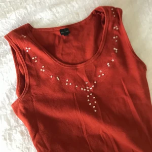 Röd topp med gemstones - Säljer denna Super snygga toppen med små stenar!!!☺️💗💗 skulle säga att den passar s-m🥰säljer även mycket annat liknande och kommer lägga upp mer så småningom☺️❤️