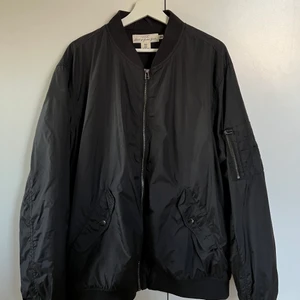 Svart bomber jacka - Bomber jacka från H&M. Använd ett fåtal gånger. Bra skick. Storlek XL. En inne ficka och en ficka på armen. 