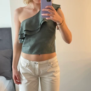 One skolfest top med volang  - Så söt grön top med volang. Hade innan ett band man kunde fästa på andra sidan för att inte ha den off shoulder (se bild 3). Denna slängde jag när jag köpte toppen då jag inte ansåg att det var fint. Toppen stannar uppe bra på mig oavsett hur jag rör mig