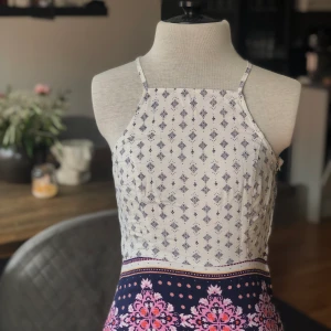 Klänning i mönster  - Klänning i mönster, vit, blå, rosa och orange. Sparsamt använd. Storlek S.   Mått på docka  Byst: 76  Midja: 65cm Stuss: 96 cm  För fler bilder eller frågor kring frakt är det bara att skicka iväg ett PM! 📦📸