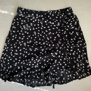 Blommig kjol - Säljer denna superfina blommiga kjol då den ej kommer till användning💕 Märket är Garage och köptes i usa. Den har en rynkning vid låret som gör den väldigt smickrande💕 säljer även en tillhörande topp!