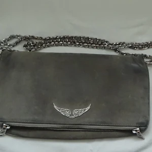 Zadig väska  - Grå Zadig väska köpt här på Plick, den kom sliten och är i samma skick nu, därav sänkt pris. Köpare står för frakt. Betalning sker via Swish. väska och långt band medföljer.