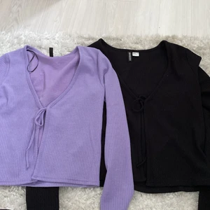 Svart och lila snyt topp - Jag säljer en svart och en lila topp. Båda är från hm och man knyter dom fram. Dom är så fina och ha en topp under eller utan. Den svarta är i storlek M och den lila i storlek S men dom båda är väldigt stretchiga och mjuka i matrialet. Pris är var för sig