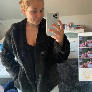 Jacka zara storlek xs - ”Päls” jacka som är svart från Zara i storlek xs. Mitten knappen är lite lös men fungerar fortfarande. Den är superskön och har även en luva som man kan se på andra bilden. I bra skick om man bortser från knappen. Den har även fickor!