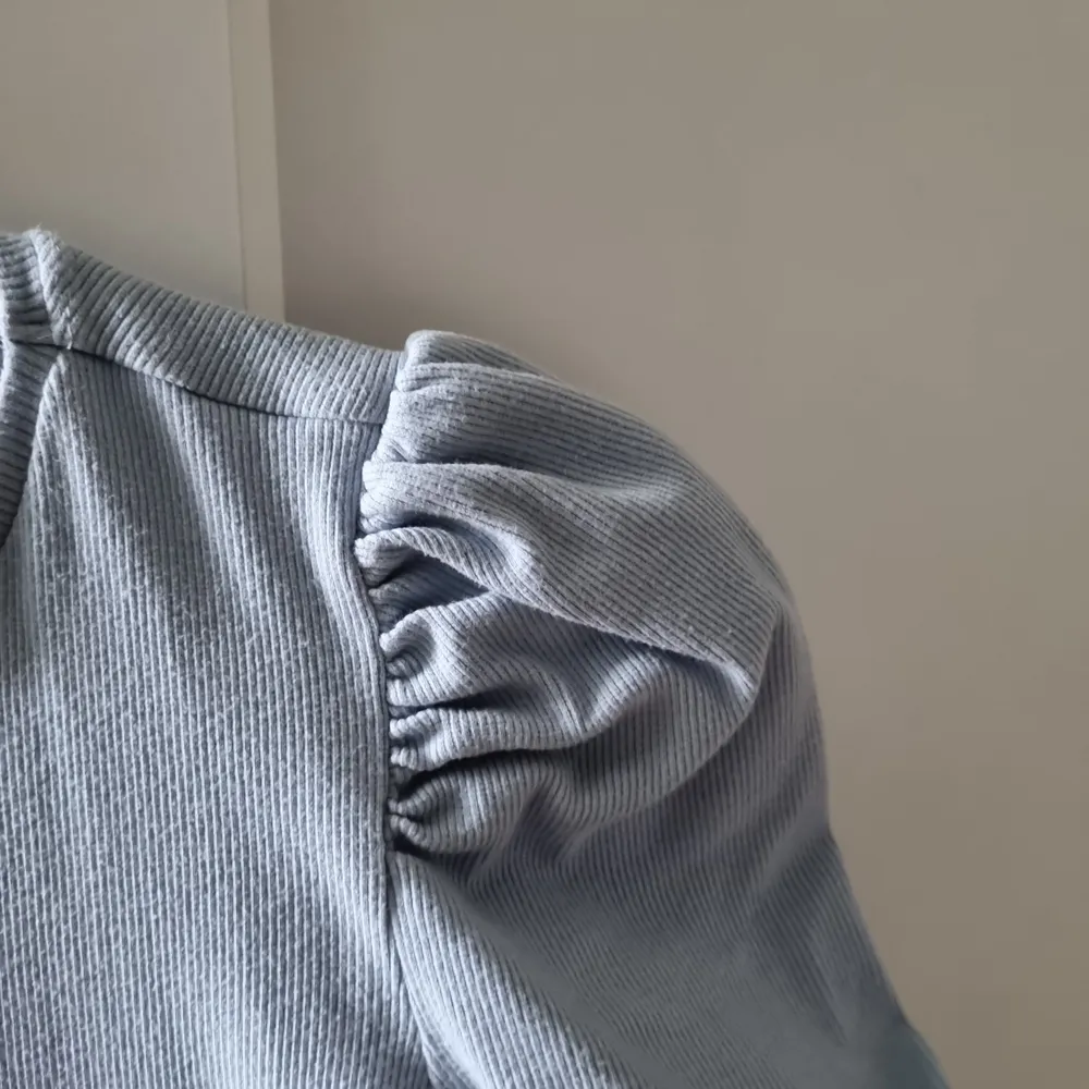 En ljusblå tröja med trekvartsärm i storlek S. Den sitter jättefint på och de puffiga ärmarna gör den extrafin. . T-shirts.