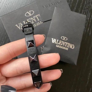 Valentino armband - !1a bild lånad! Säljer mitt fina svarta armband med mörka nitar. Köpte det nyligen från Plick i väldigt bra skick men har tyvärr inte äkthetsbevis eller box:( . Fortfarande superskick! Skriv vid frågor❣️