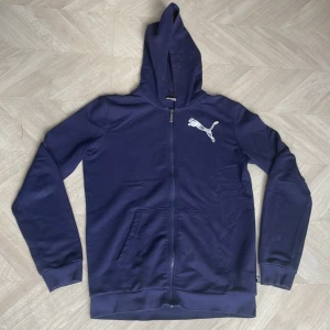 PUMA Zip-up - Mörkblå zip-up från PUMA med vitt tryck på framsidan och baksidan,  storlek 164 (se tredje bilden). Bra skick, inga hål, inga fläckar som inte går bort i tvätten.