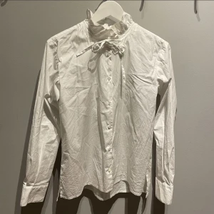 Vit knytblus i strl S  - Snygg och elegant knytblus i vitt. Knappt använd, i mycket gott skick! Från märket Naja Lauf. 