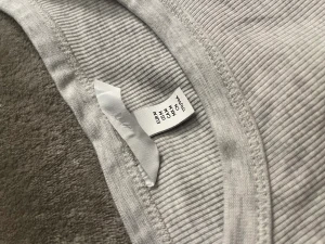 Ljusgrått linne - Säljer detta snygga linne ifrån hm. Det är melerat i ljusgrå. Använt 1-2 gånger. Säljer för att det är lite för stort på mig så banden åker ner😭 skriv för bild på!