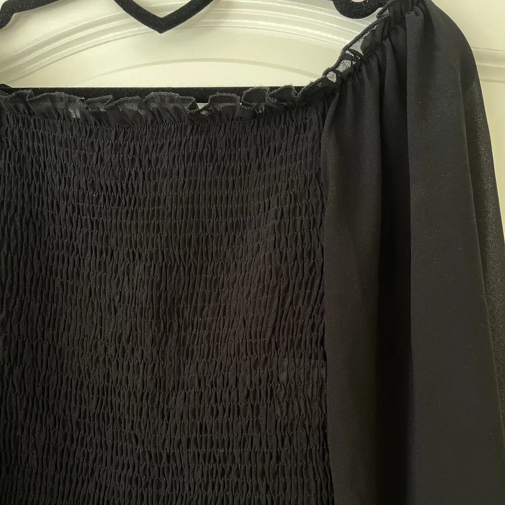 Svart blus från Sisters Point Storlek S Smockad topp med lätt ballongärm och liten volang Kan användas som off-shoulder eller fyrkantig ringning Använd ett fåtal gånger, fint skick utan anmärkningar  130 kr . Blusar.