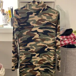 Militärmönstrad klänning från Gina tricot i storlek Xs, mer som en S. Skönt material och relativt tunn. Den har hög hals/nacke och är långärmad. 35kr+frakt