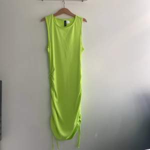 Neon grön klänning med scrunch på sidorna. Köparen står för frakten 