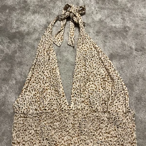 Topp - Topp i ett väldigt tunna material, går att knyta bakom nacken och på så sätt justera den lite själv 