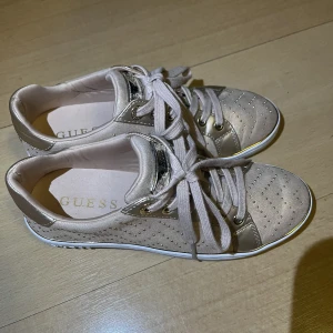 Guess Skor - Köpta i Guess-butik i Budapest februari 2020. Användes då ett fåtal gånger, var lite för små, så har inte använts sedan dess. Har ej kvar kvittot. Passar nog en liten 37, kanske mot 36. Minns ej pris men runt 1000-1300. Roséguldiga, jättefina till våren! 