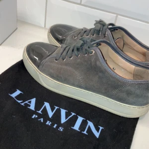 Lanvin Skor - Hej, säljer mina Lanvin cap toe skor. Skorna passar 40/41 och är i bra skick. Finns en defekt på höger sko fram som syns bättre på sista bilden. Dustbag ingår. Nypris 3999kr. Dm för fler bilder. BUD på 2300 :-